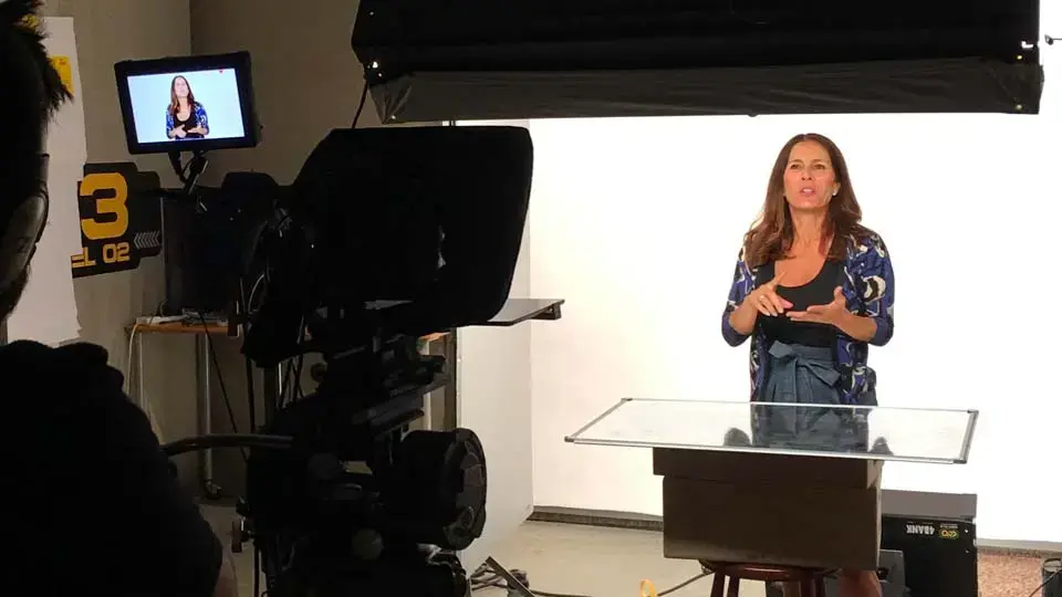 Talent standing on a gray seamless backdrop in a pre-lit interview set