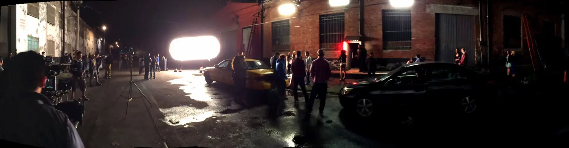Panoramic view of a film production stage with crew, cameras, and lighting